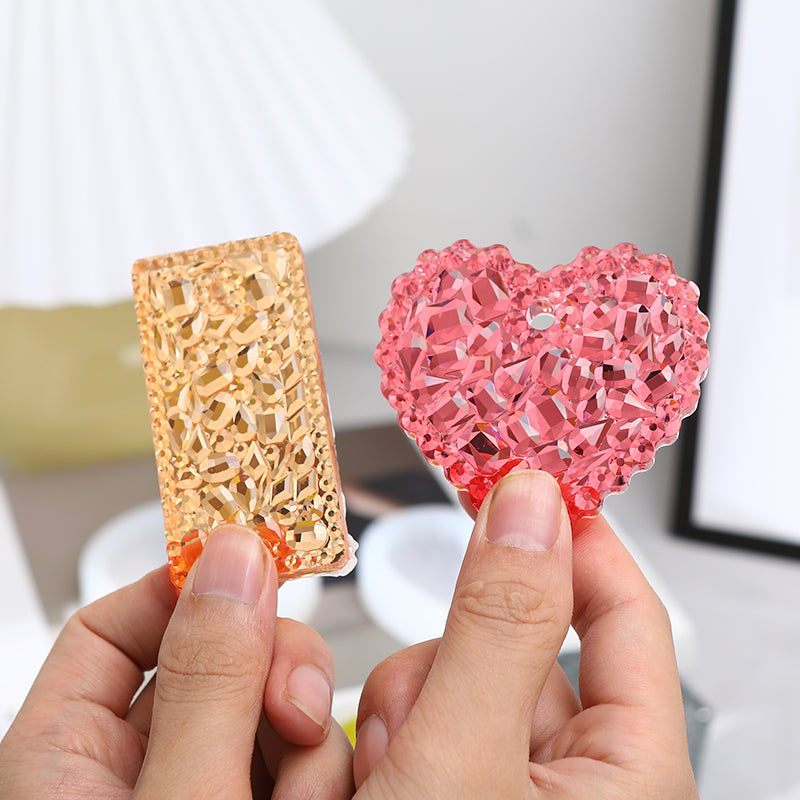 Hands hold a pink heart-shaped silicone resin mold for DIY jewelry making