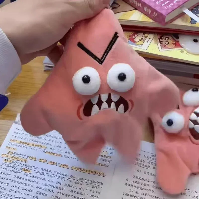 A pink plush toy with large eyes and a black nose, resembling an expressive star character.