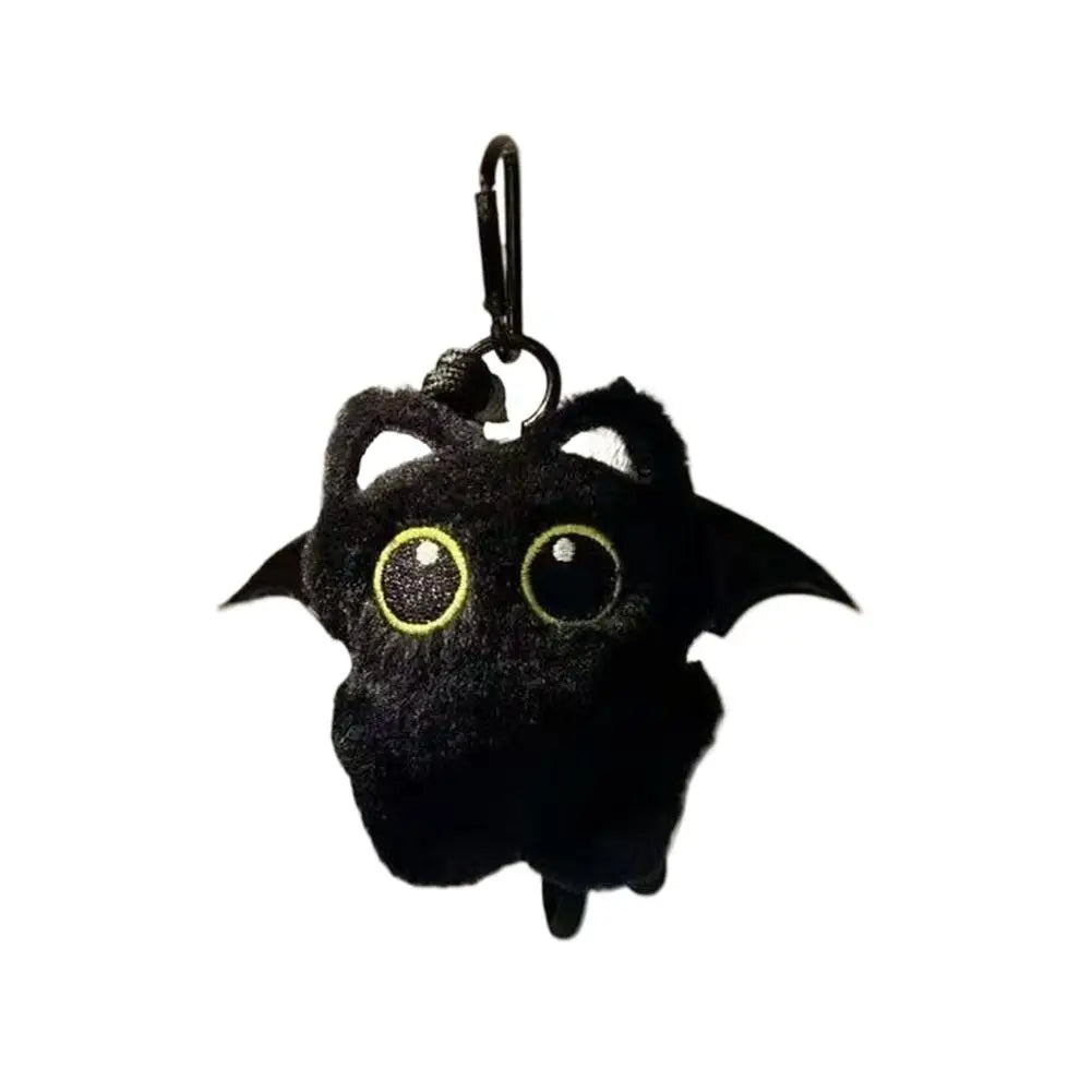 A black plush cat keychain with large yellow eyes and a metal loop.