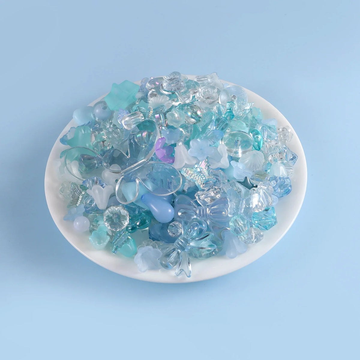 A pile of assorted light blue and teal acrylic beads for DIY jewelry making
