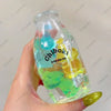 A hand holds a clear plastic bottle filled with colorful squishy toys, labeled Chiboki drink cup toy.