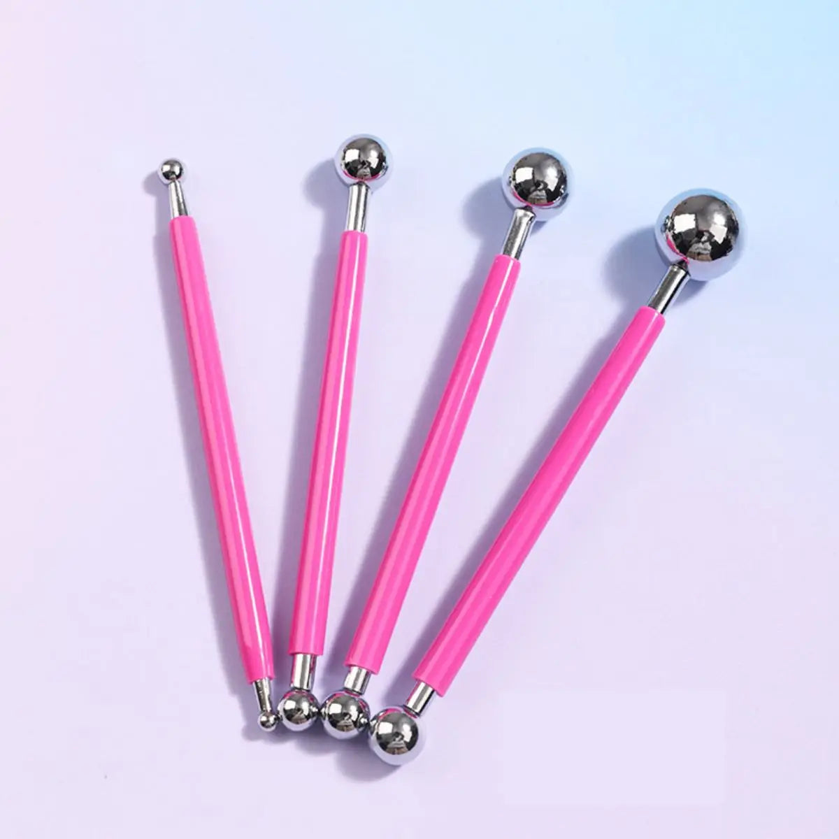 A set of four pink and silver clay sculpting tools for pottery and crafting