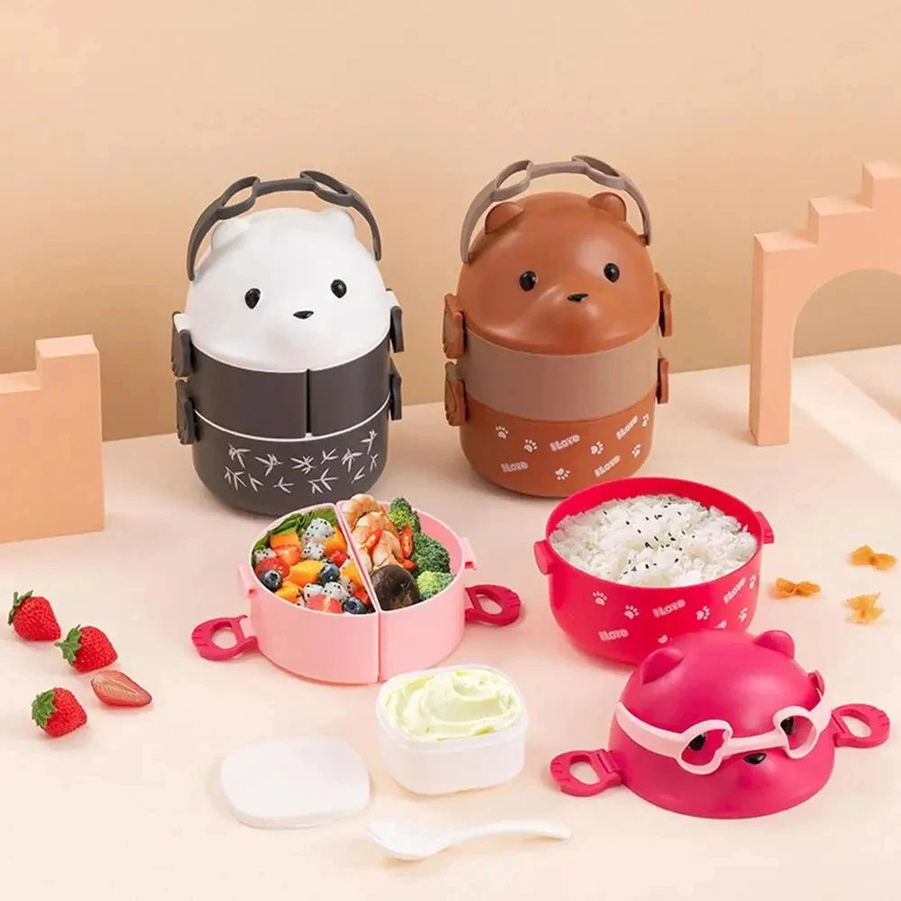 A set of adorable bear-shaped stackable bento lunch boxes in pink, brown, and white with accompanying accessories.