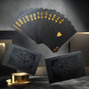 A stack of black playing cards with gold accents and a single heart card displayed against a dark background.