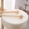 A wooden kids drum set with two wooden mallets resting on a white drum surface.