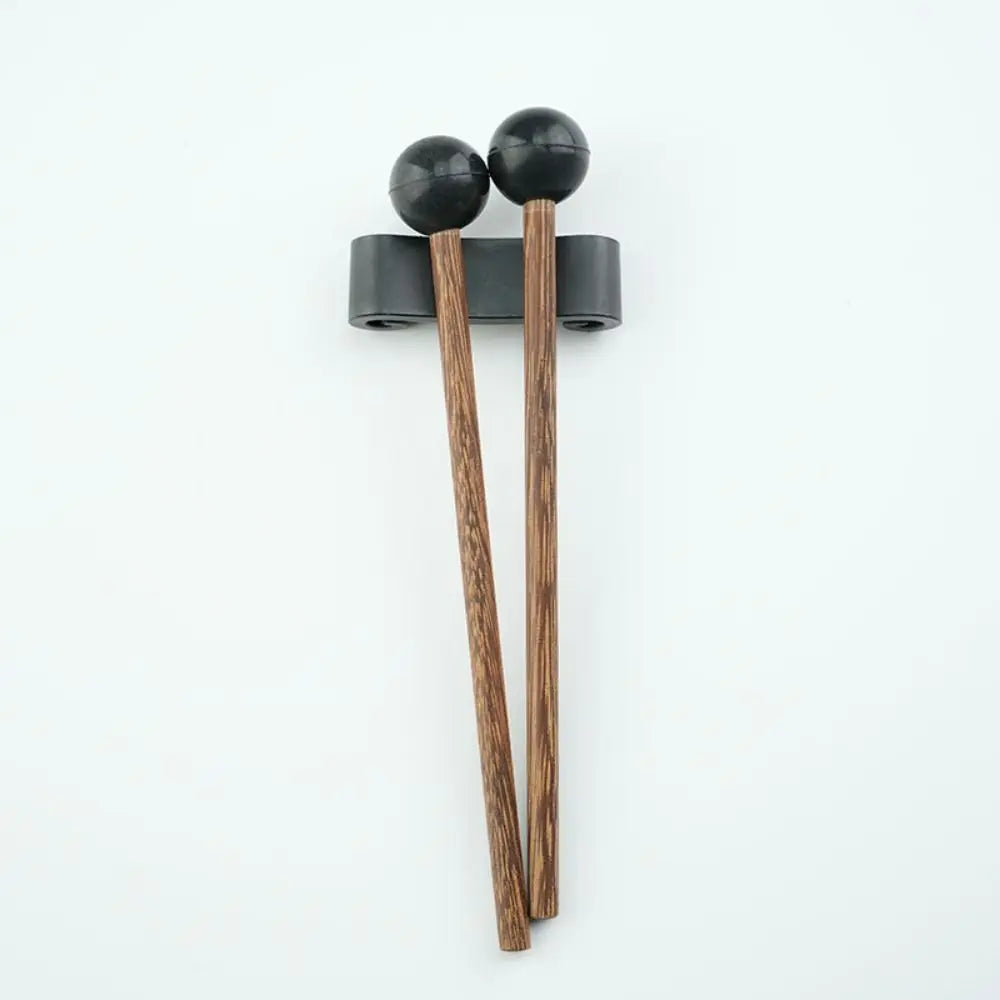 A pair of wooden handpan drum mallets with black silicone tips resting on a white background.