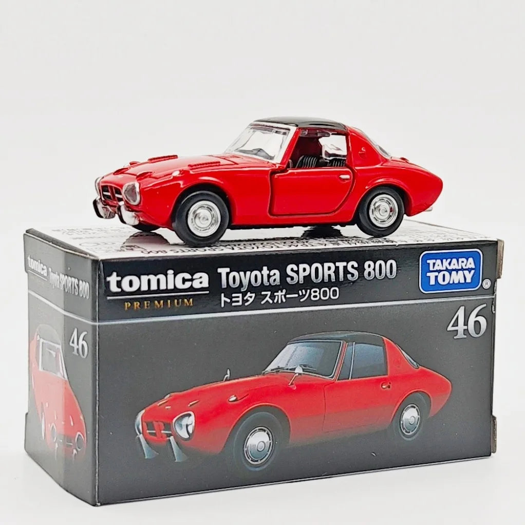 A red Tomica Toyota Sports 800 die-cast model car displayed in its packaging box.