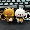 A set of two cute cartoon bear keychains, one orange and one white, featuring a playful design.