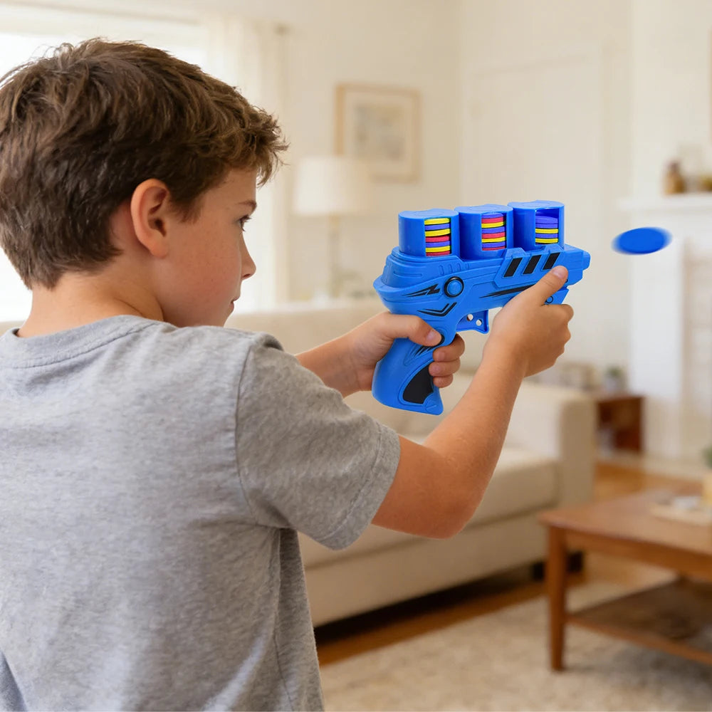 A boy is holding and aiming a blue soft foam flying disc launcher toy for kids.