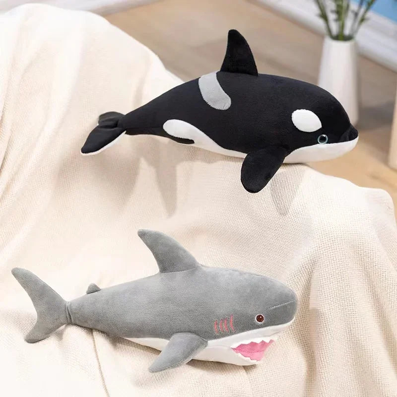 A plush stuffed animal set featuring a black killer whale and a gray great white shark