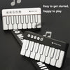 A white pocket piano keyboard is shown, featuring musical notes and controls, set against a dark background.