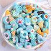A bowl filled with assorted blue and pink candy resin flatbacks for DIY crafts and jewelry making