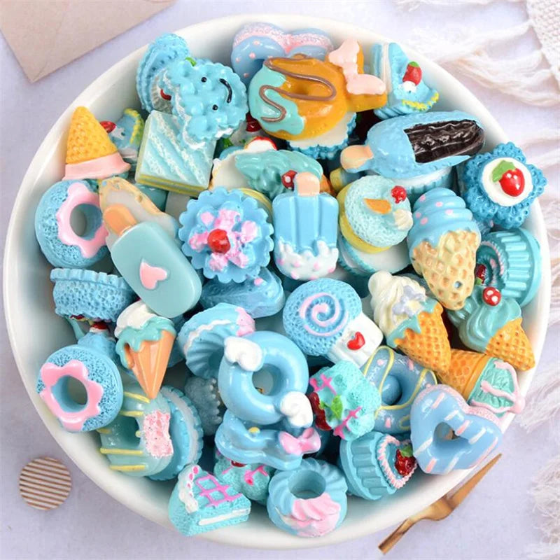 A bowl filled with assorted blue and pink candy resin flatbacks for DIY crafts and jewelry making