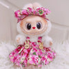 A cute doll wearing a pink floral dress and bow, with white fluffy hair and facial features.