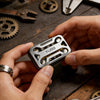 A hand holds a silver metal magnetic fidget slider device against a dark wooden background.