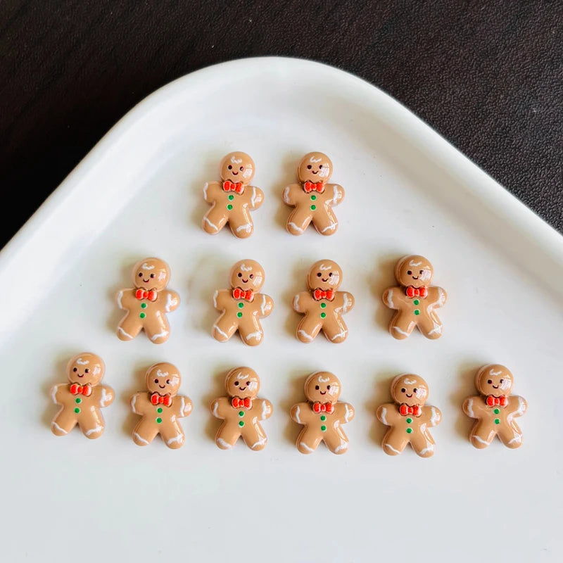 A white oval dish holds 12 small gingerbread man resin charms with red accents.