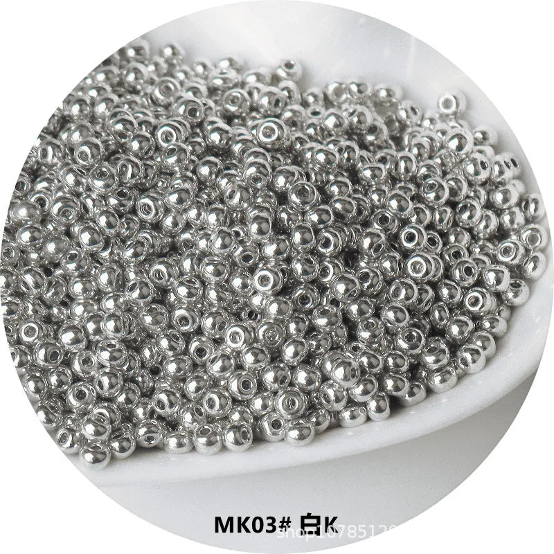 A pile of small, silver-colored electroplated metallic glass beads for jewelry and crafting.