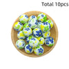 A collection of ten white and blue floral printed silicone beads arranged on a wooden plate.