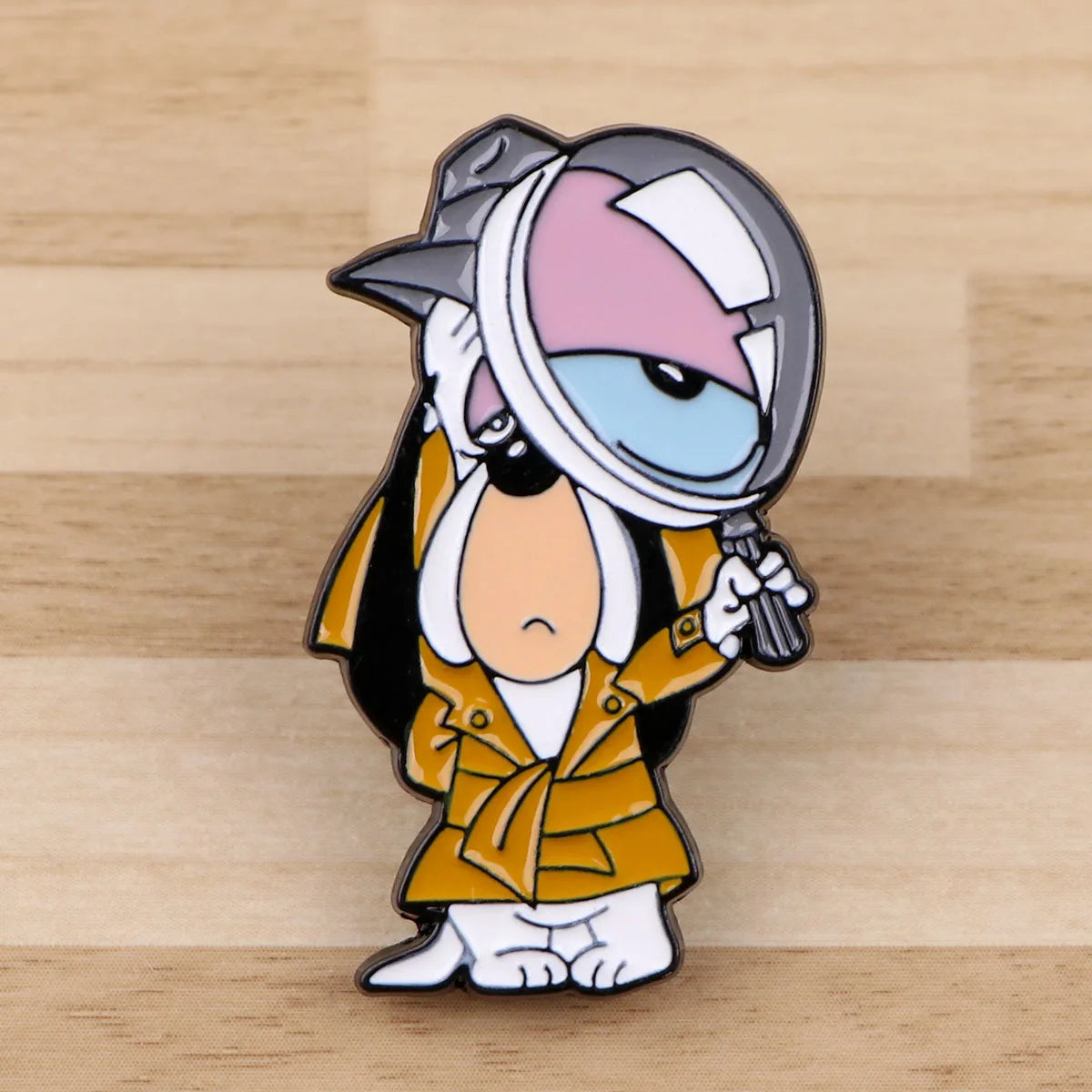 An enamel pin featuring a cartoon dog character wearing a helmet and a yellow jacket.