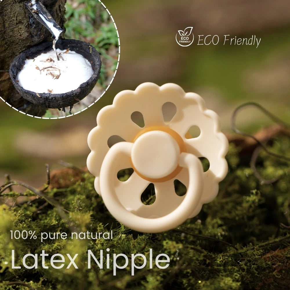 A light beige latex nipple pacifier resting on green moss with a dripping liquid in the background.