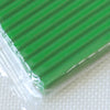 A close-up view of a green polymer clay kit with soft modeling clay wrapped in clear plastic.