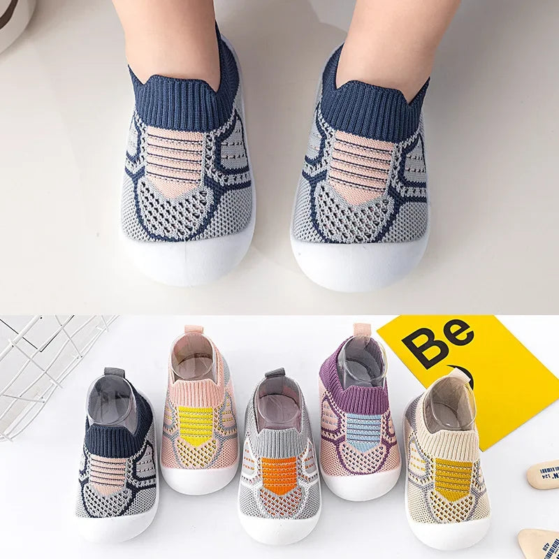 A pair of breathable anti-slip baby first walker shoes in gray and white knitted fabric shown from the top view.