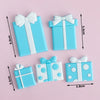 Light blue rectangular cake toppers with white ribbon bows and polka dots for birthday or baby shower