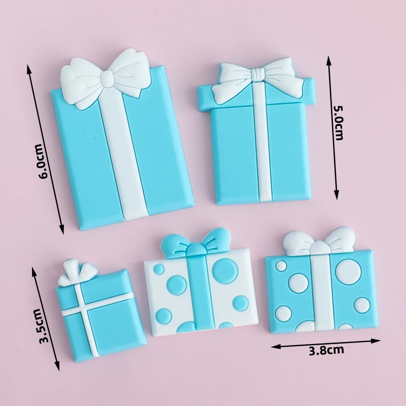 Light blue rectangular cake toppers with white ribbon bows and polka dots for birthday or baby shower