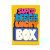 A yellow box for the Super Mega Lucky Box board game featuring colorful text and a box design.