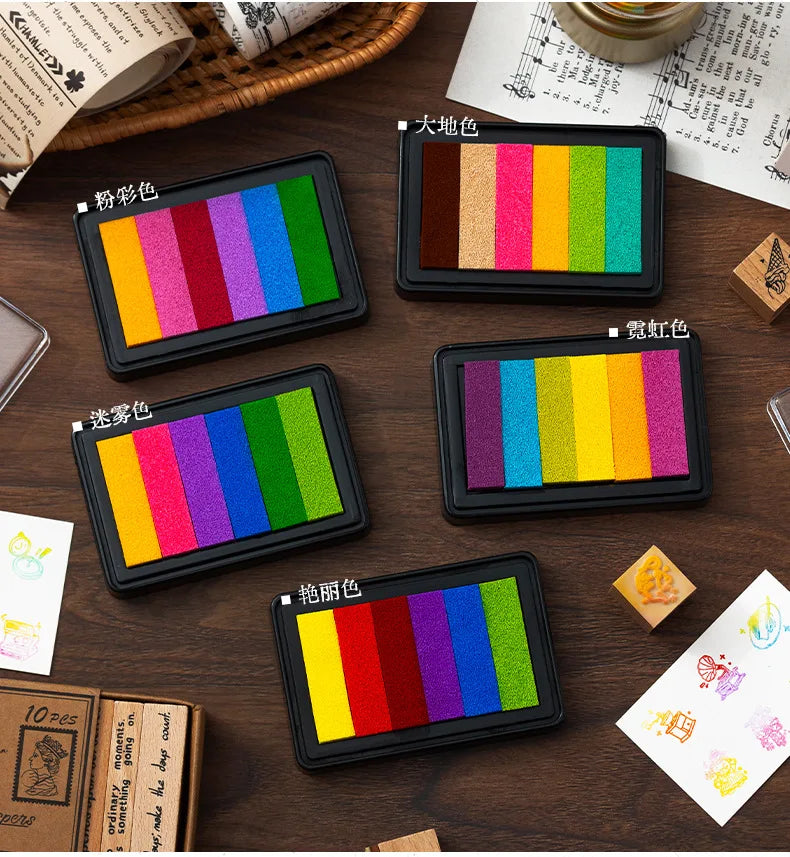A set of six large rectangular rainbow gradient ink pads for stamping and crafts displayed on a wooden surface.