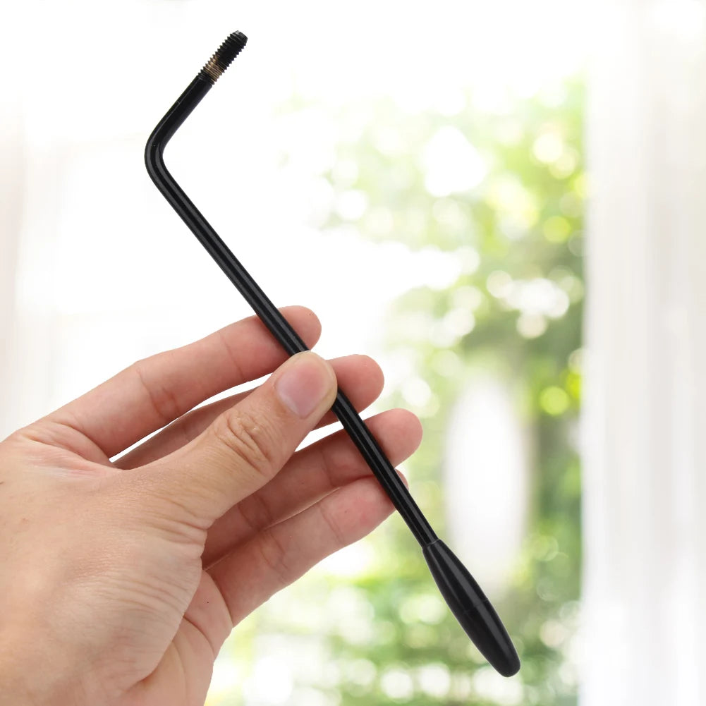 A hand holds a black replacement tremolo arm for an electric guitar.