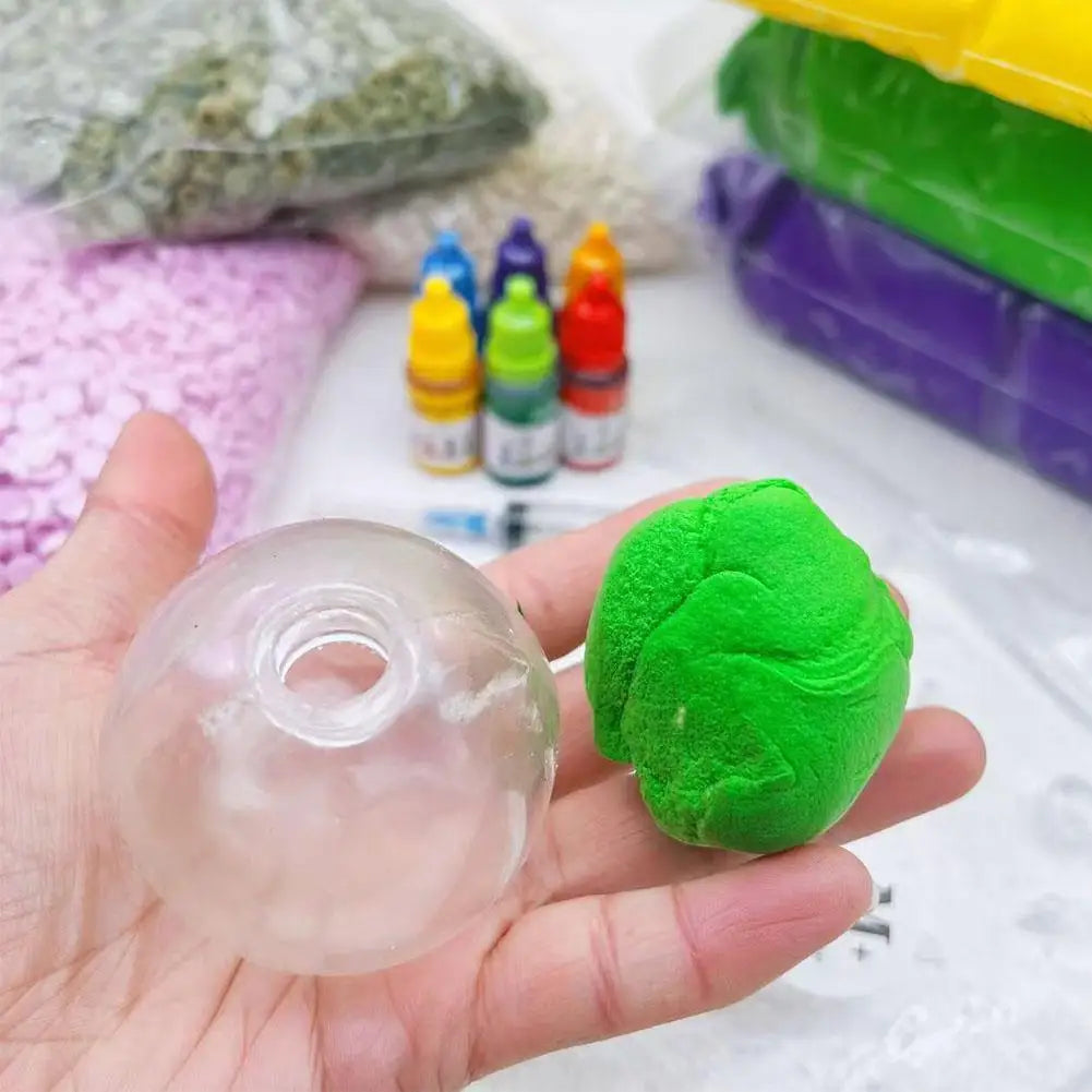 A hand holds a clear plastic squishy stress ball cover next to a green squishy stress ball.