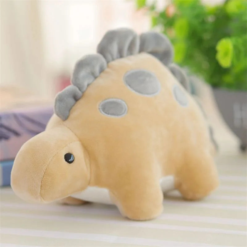 A soft, light brown plush dinosaur toy resembling a triceratops with gray spikes and spots.