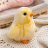 A fluffy yellow chick plush toy with an orange beak resting on a light fabric surface.