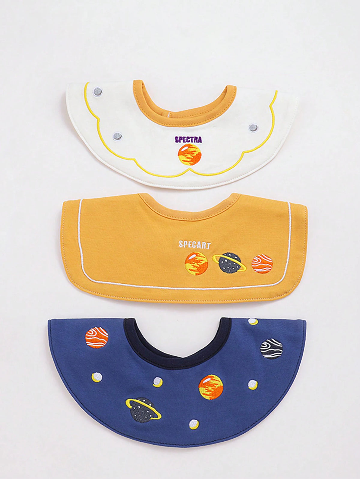 A set of three baby waterproof drool bibs in yellow, orange, and blue with various designs.