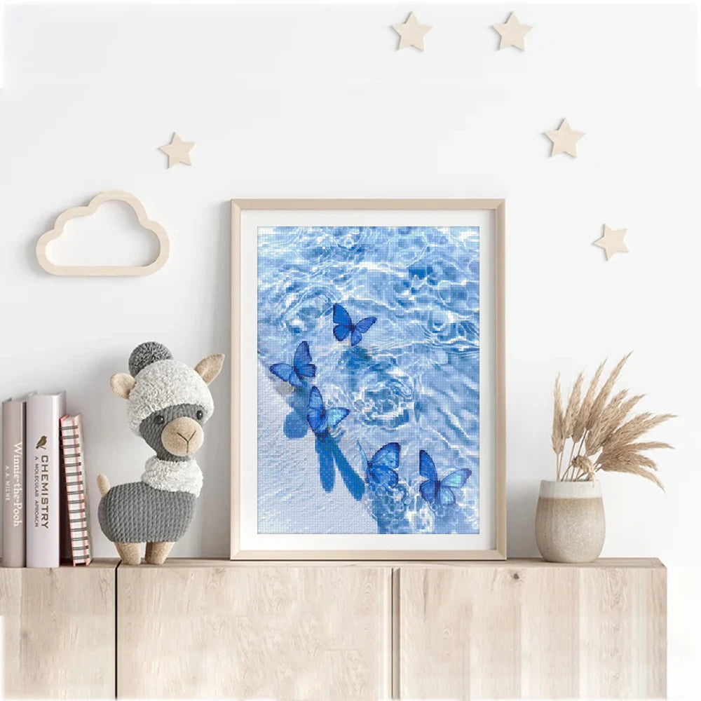 A framed picture of blue butterflies swimming in clear water displayed on a white wall.