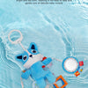 A blue plush toy resembling a dog is shown floating in clear water, with various hanging toys nearby.