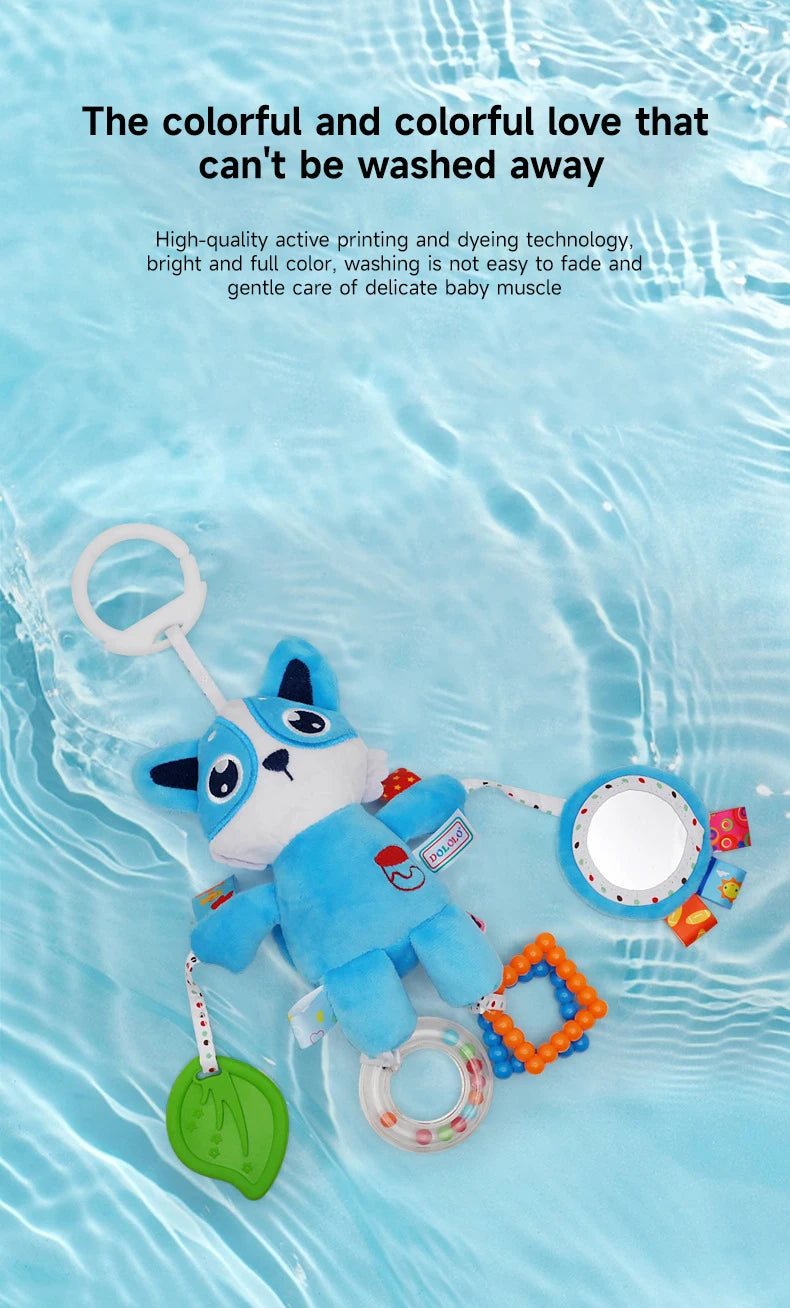 A blue plush toy resembling a dog is shown floating in clear water, with various hanging toys nearby.