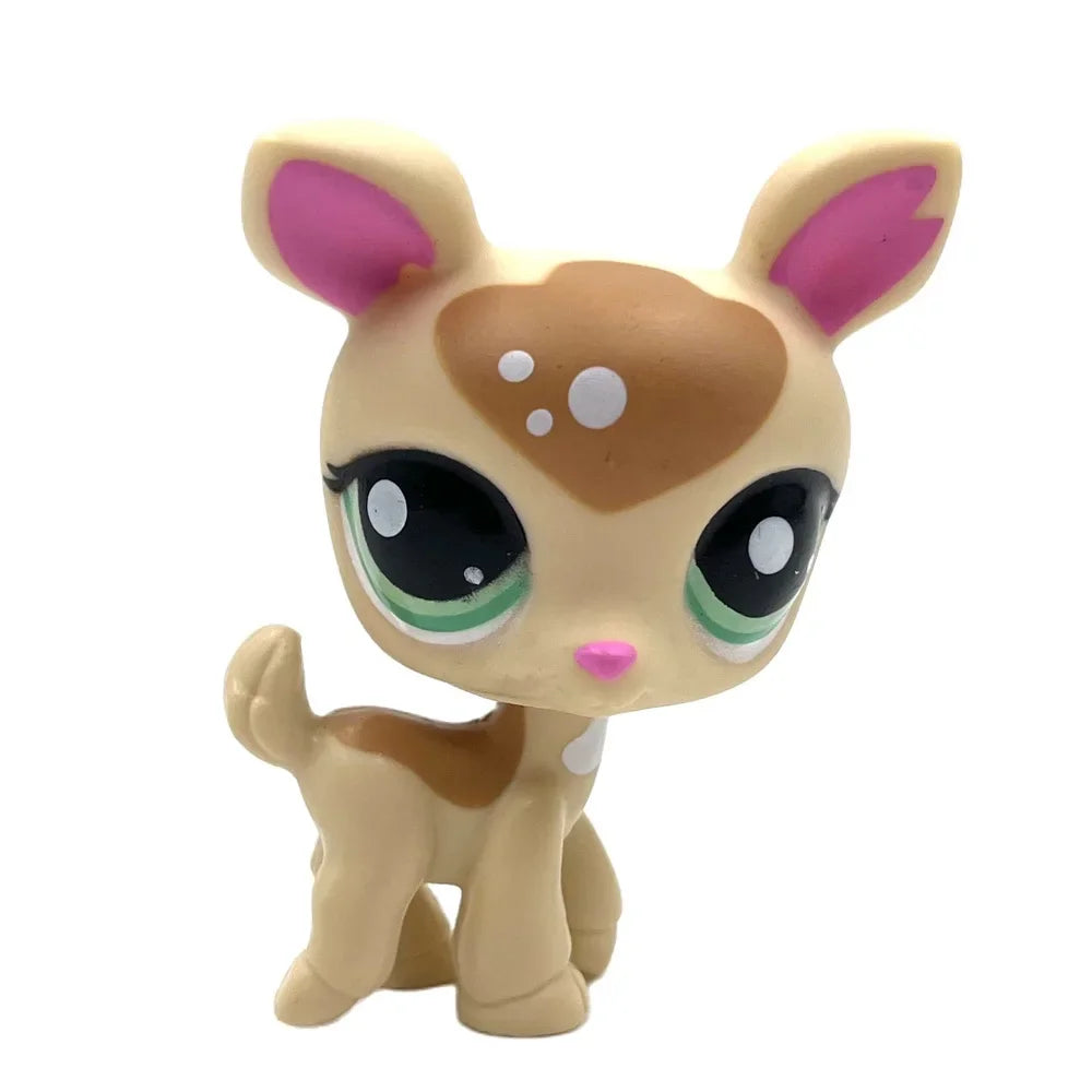 A small, light brown bobblehead toy of a deer with pink inner ears and large green glowing eyes.