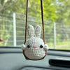 Handmade crochet bunny animal hanging ornament with brown string and attached to a car window.