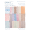 A collection of various shades and textures of paper sheets for scrapbooking, including light pinks, blues, and tans.