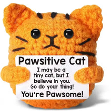 An orange crocheted cat toy with black stripes, designed as an inspirational desk decor item.