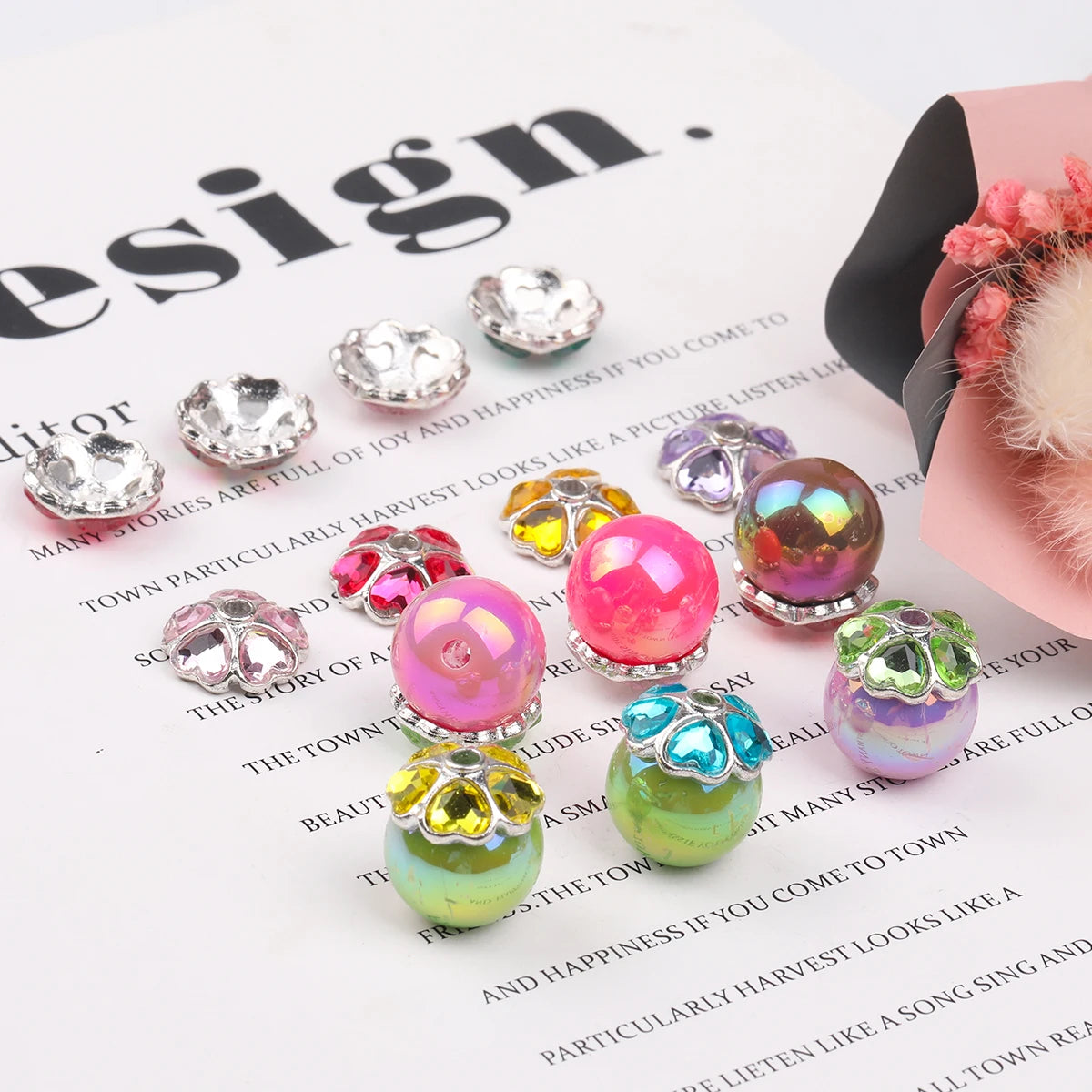 A collection of heart-shaped rhinestone flower charms beads in various colors and finishes displayed on a white background.