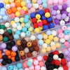 A collection of colorful matte acrylic beads in various shades including orange, yellow, pink, blue, and black.
