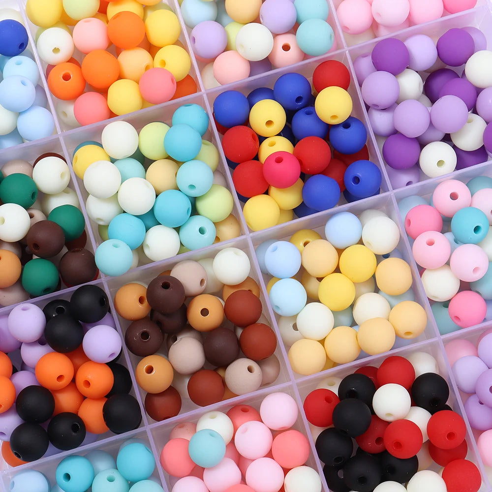 A collection of colorful matte acrylic beads in various shades including orange, yellow, pink, blue, and black.