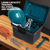 A teal toolbox is open, showing various tools and a helmet, with spare tools laid out on a wooden surface.