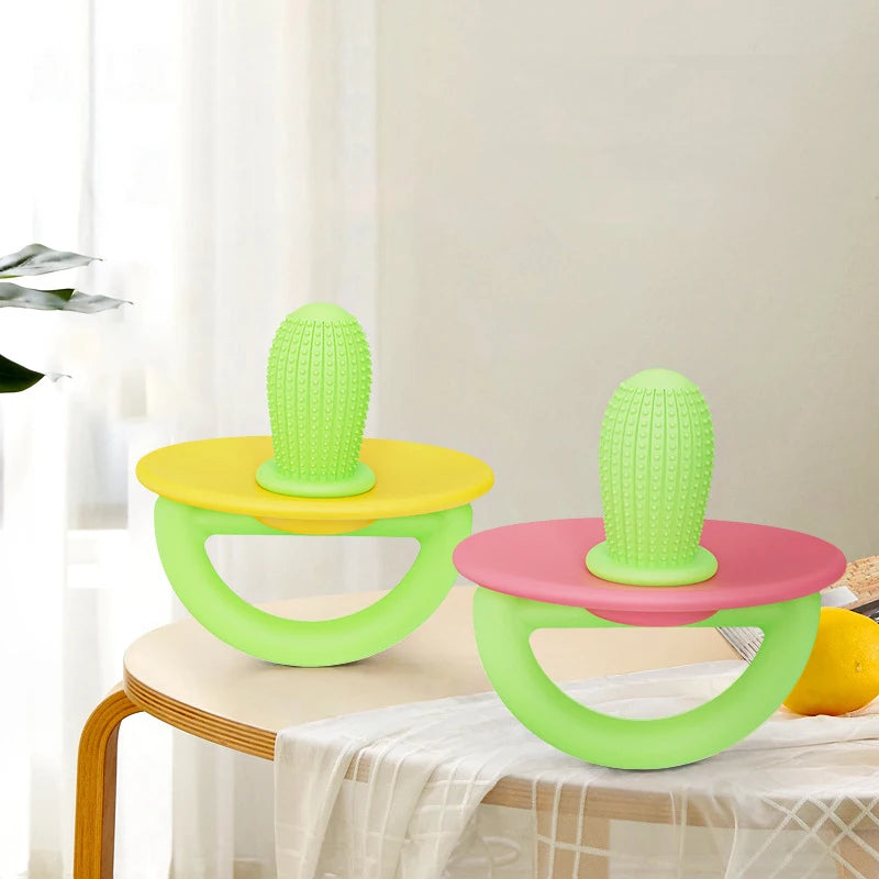 Two bright green silicone teething rings with yellow and pink accents displayed on a white table.