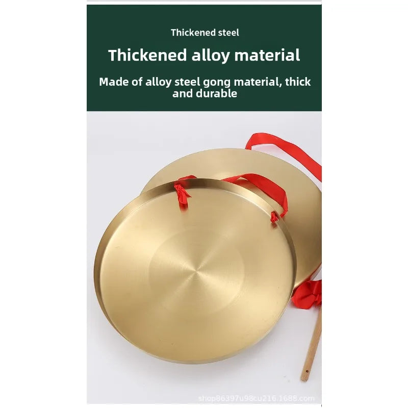 A polished gold-colored alloy gong with a red mallet, used for meditation and ceremonial purposes.