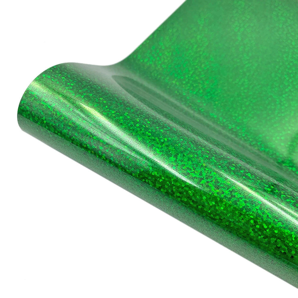 A close-up view of a sheet of green glitter holographic heat transfer vinyl rolled up.