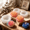 A collection of pink and blue floral silicone candle molds resting on a wooden surface.